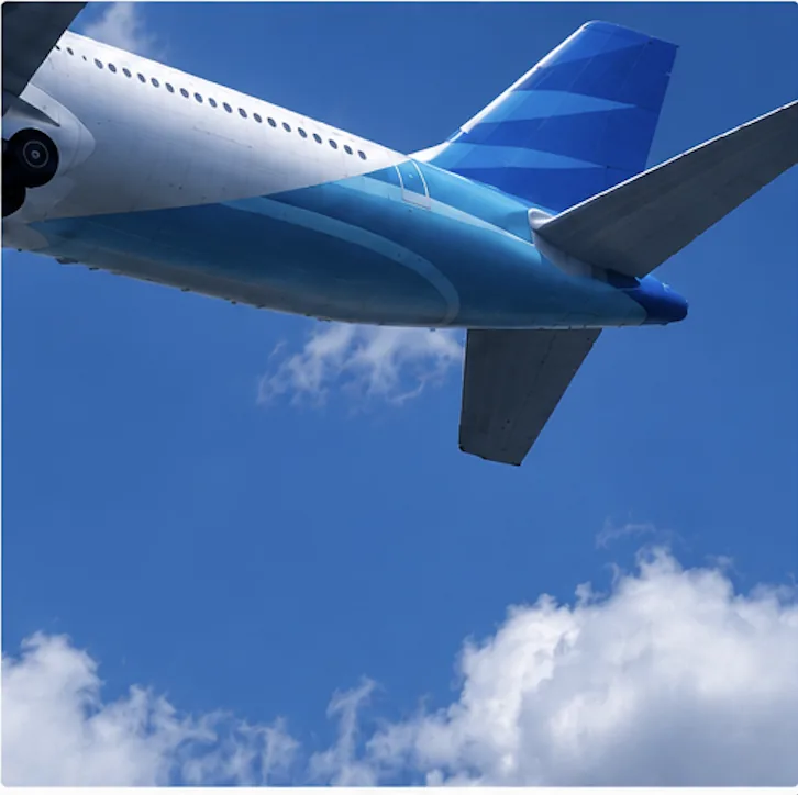 Cola de un avión contra un cielo azul con nubes
