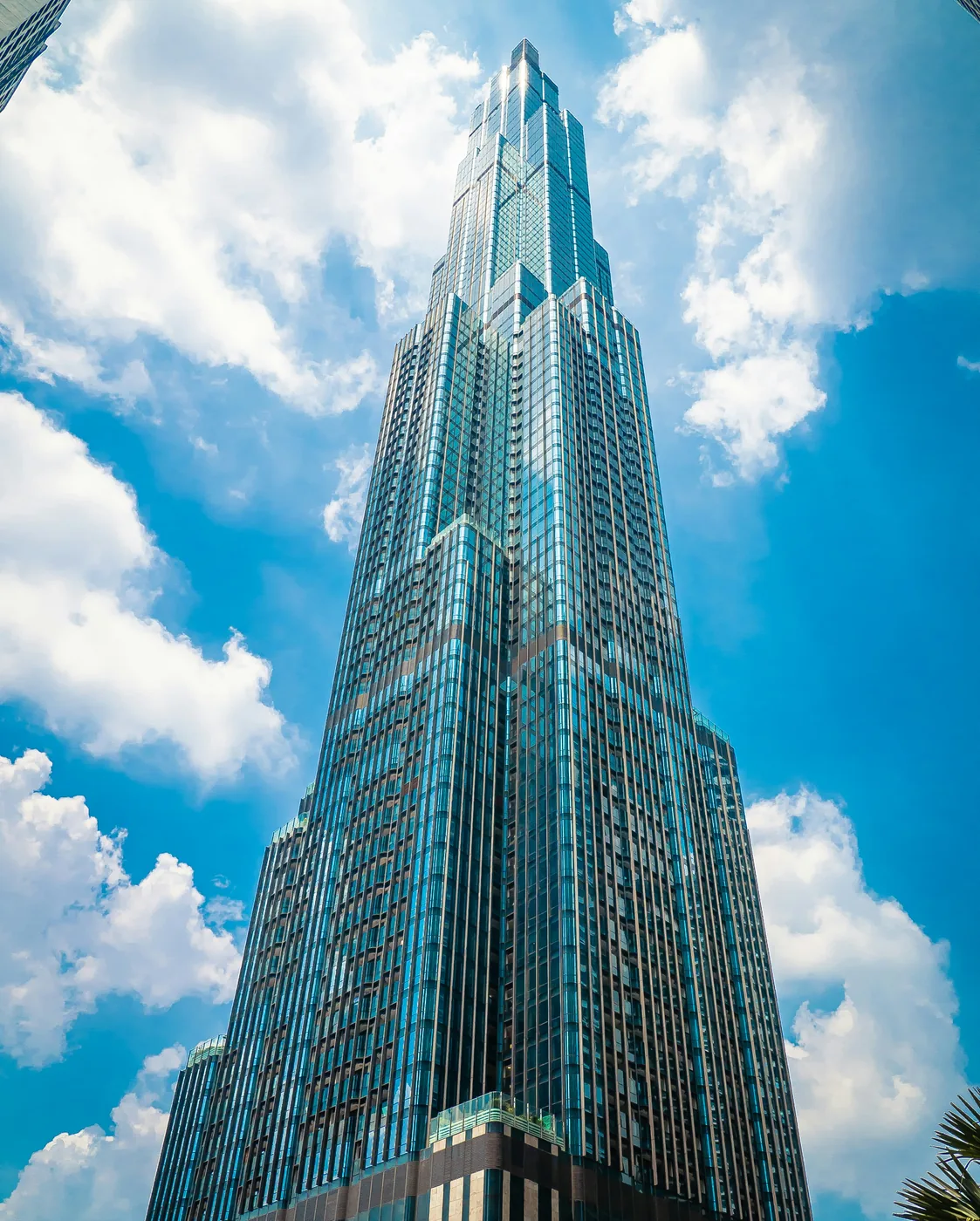Skyscraper seen from below against a blue sky with clouds